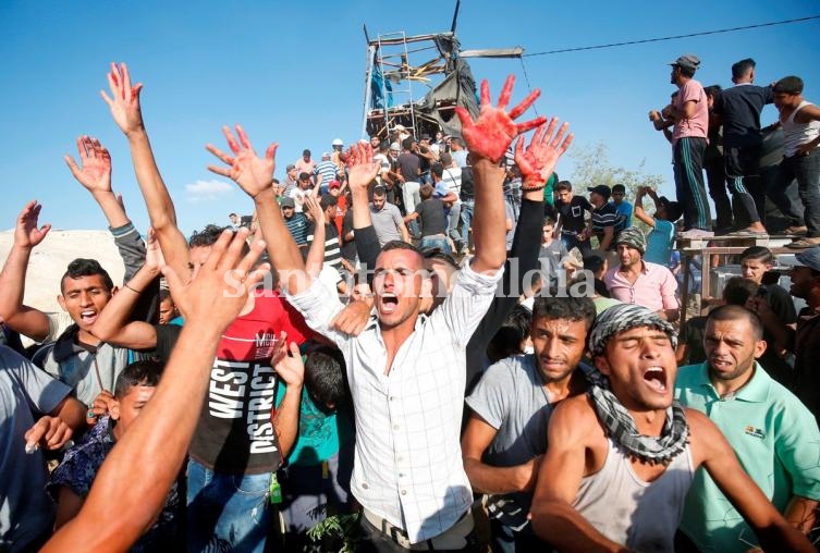 Los palestinos reaccionan con manos ensangrentadas frente a un puesto avanzado de Hamas que fue bombardeado.