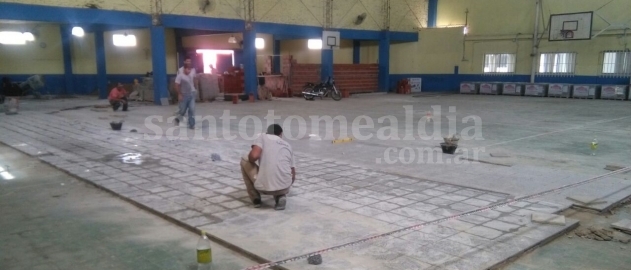Albañiles colocan el nuevo piso del gimnasio. (Foto: Gentileza J.C. Oldani)