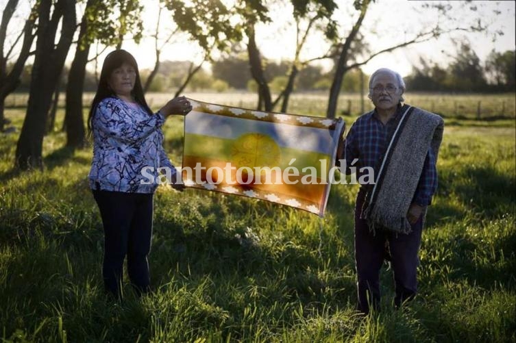 En Los Toldos, la lonco Lilli y Nilo, el vocero del grupo, sostienen la bandera mapuche. (Foto: LA NACION)