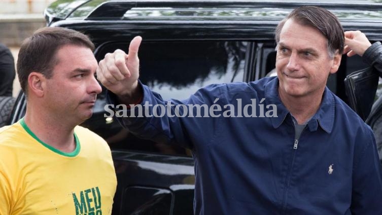 Jair Bolsonaro, junto a su hijo, saluda a los seguidores ante de votar en Río de Janeiro. (Foto: AFP)