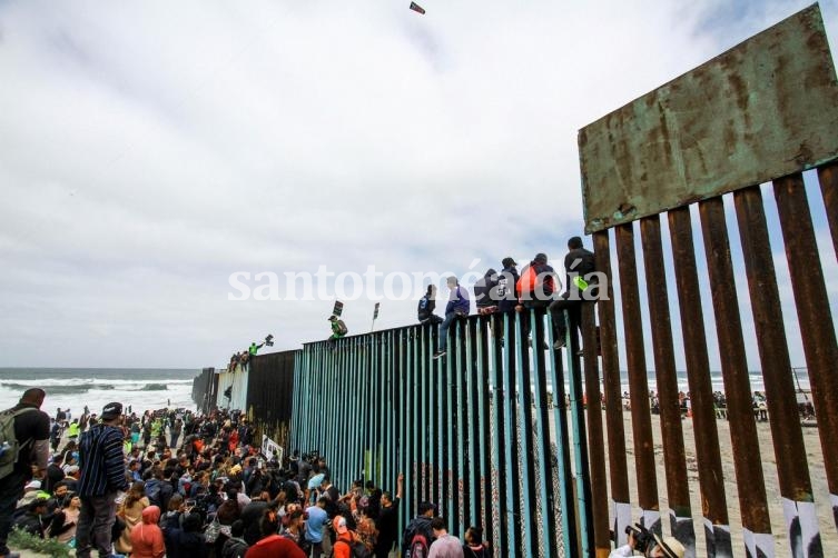 Cientos de inmigrantes se congregan en el muro fronterizo del lado de Tijuana (México) para poder cruzar a tierra estadounidense. (Foto: EFE)