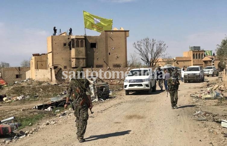 Una bandera de grandes dimensiones de las FSD fue izada sobre uno de los edificios de la localidad que terminó de ser conquistada hoy, mientras que los soldados kurdos y árabes celebraron la victoria. /REUTERS