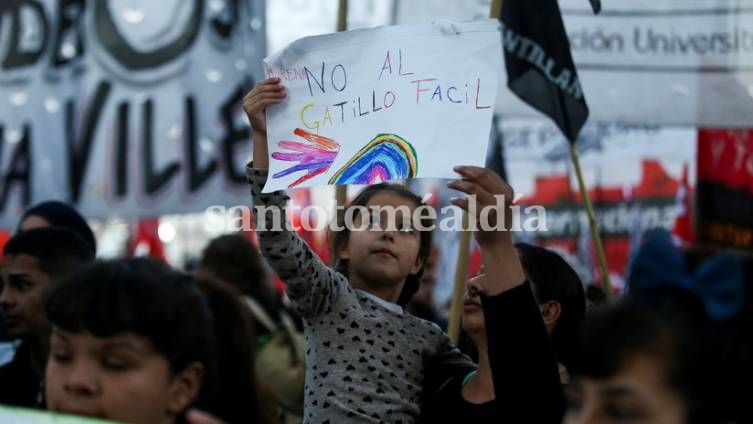 Una niña sostiene un cartel que dice 