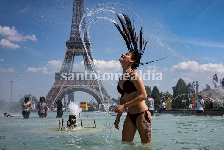 Una mujer se baña frente a la Torre Eiffel. (EFE)