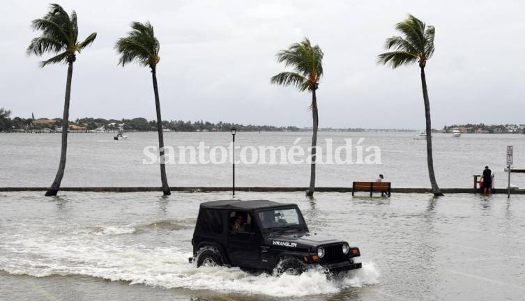 Un vehículo transita por una zona inundada en Palm Beach, Florida, antes de la llegada del huracán Dorian. (Foto: EFE)