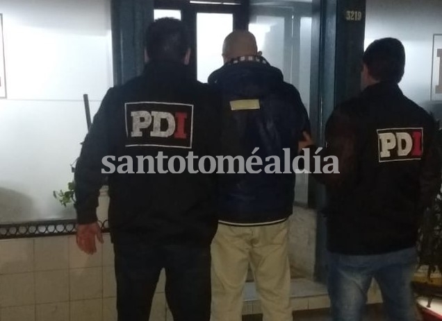 El hombre detenido, junto al personal de la PDI. (Foto: Ministerio de Seguridad)