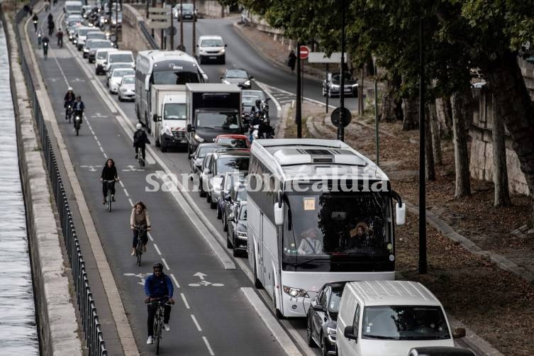 Autos varados y gente que avanza en bici, en la rivera del Sena, en París. (Foto: AFP)