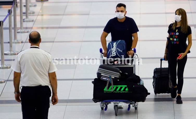 Dos pasajeros con barbijo caminan por el aeropuerto internacional de Ezeiza. (Foto: Reuters)