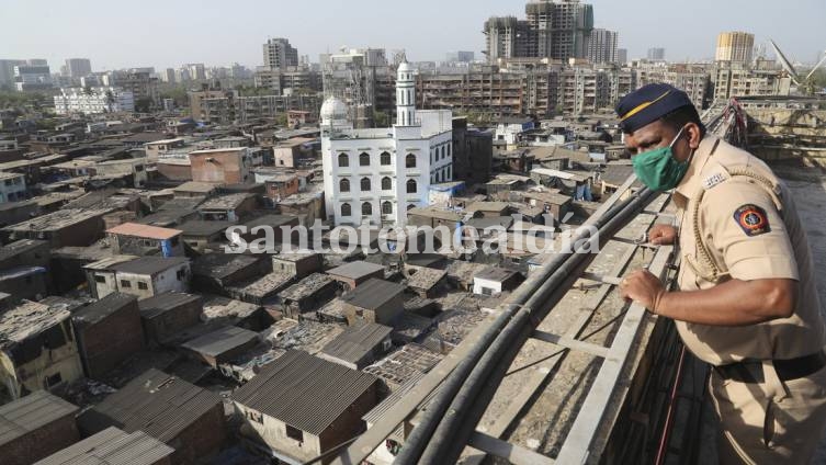 Un policía indio vigila desde lo alto de un edificio durante el cierre para evitar la propagación del nuevo coronavirus en Mumbai, India.