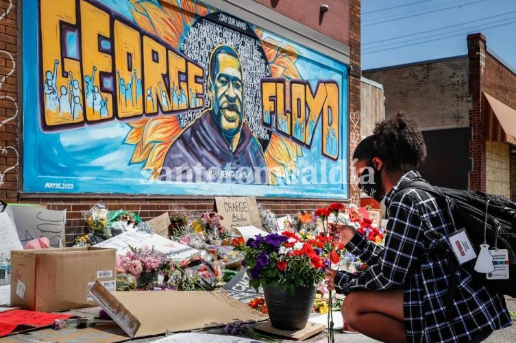 Malasia Hammond, de 19 años, coloca flores en un mural conmemorativo para George Floyd en la esquina de Chicago Avenue y 38th Street en Minneapolis. (Foto: AP )