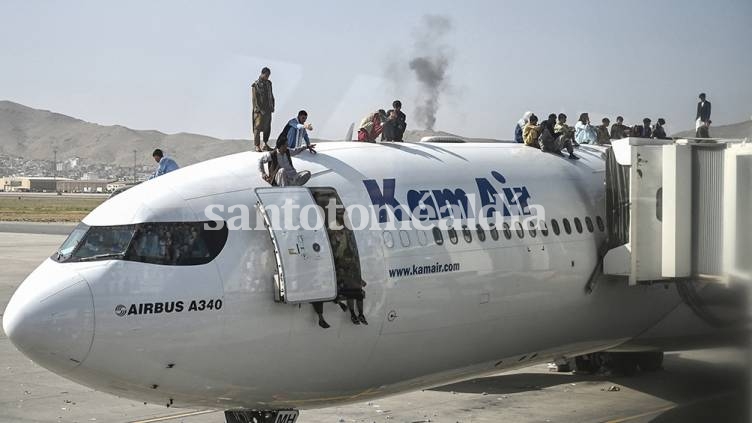 Videos colgados en las redes mostraban a grupos de jóvenes que se agarraban de las escaleras, intentando subir a un avión. (Foto: AFP)