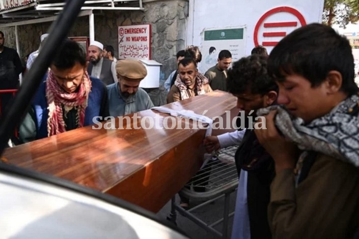 Familiares cargan el féretro de una víctima del ataque de Kabul en un automóvil.