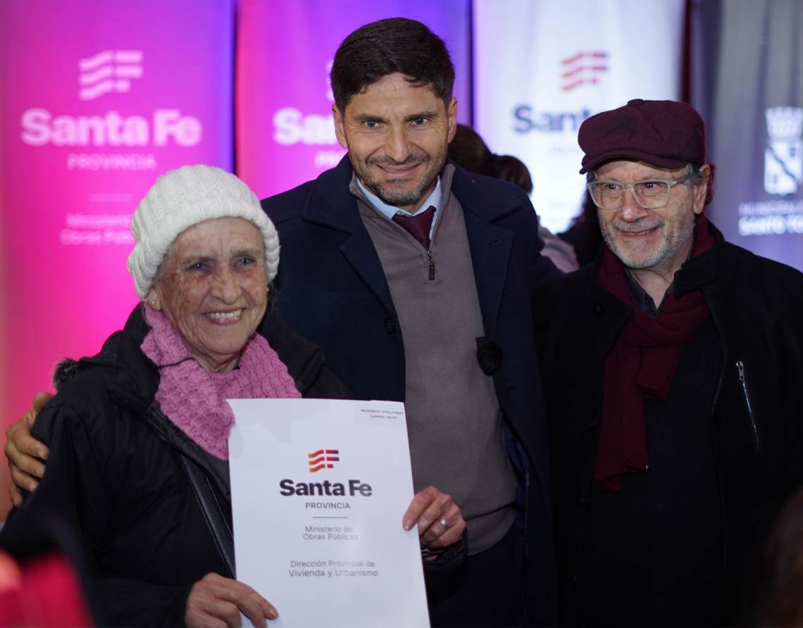 Quique Maillier y el gobernador Pullaro junto a una vecina que recibió la escritura de su vivienda.