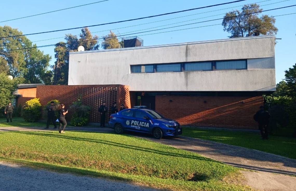 Personal de la Policía de Investigaciones en la puerta de una vivienda del country El Paso, uno de los dos domicilios allanados este martes. 