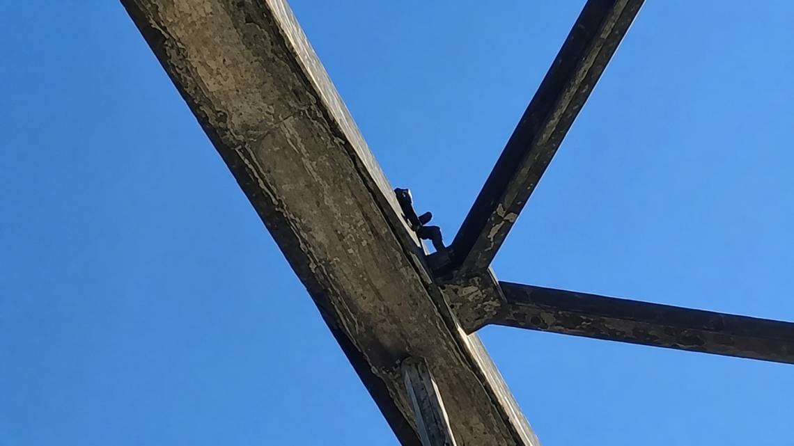 El hombre subió a lo más alto de uno de los arcos del puente.