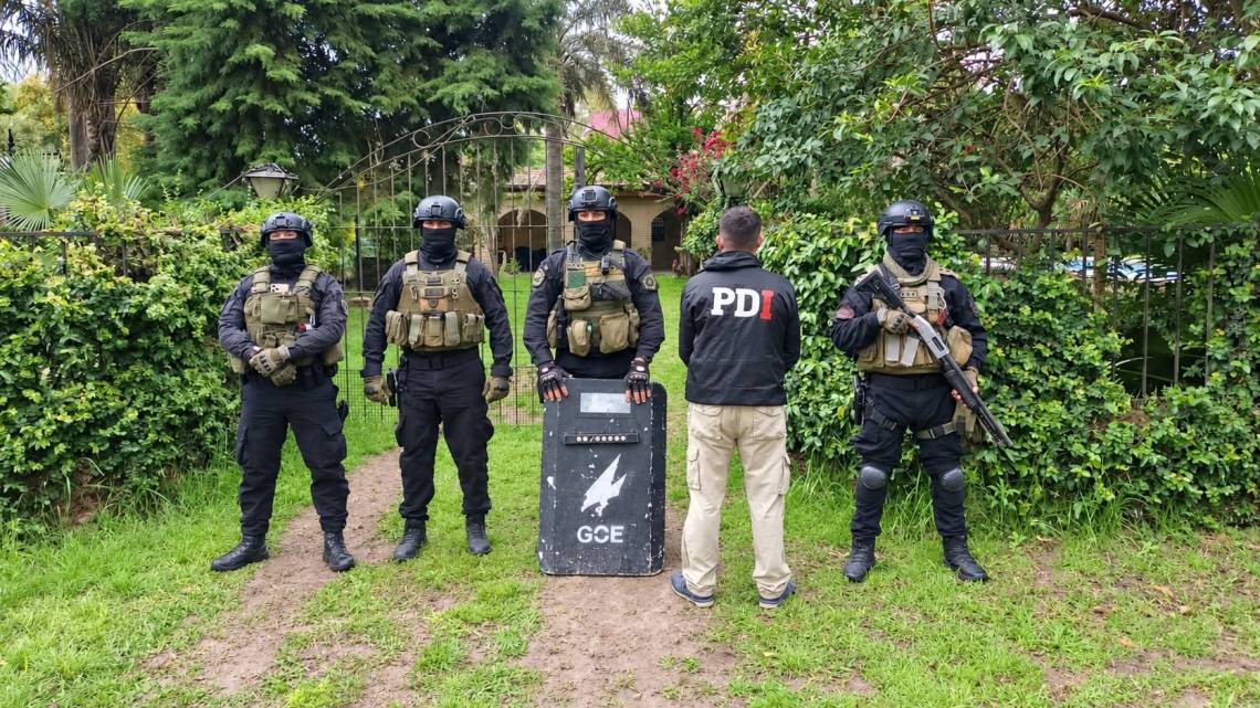 Agentes de la PDI durante el allanamiento en Sauce Viejo, donde detuvieron a una pareja investigada por amenazas en Santo Tomé. (Crédito: PDI)